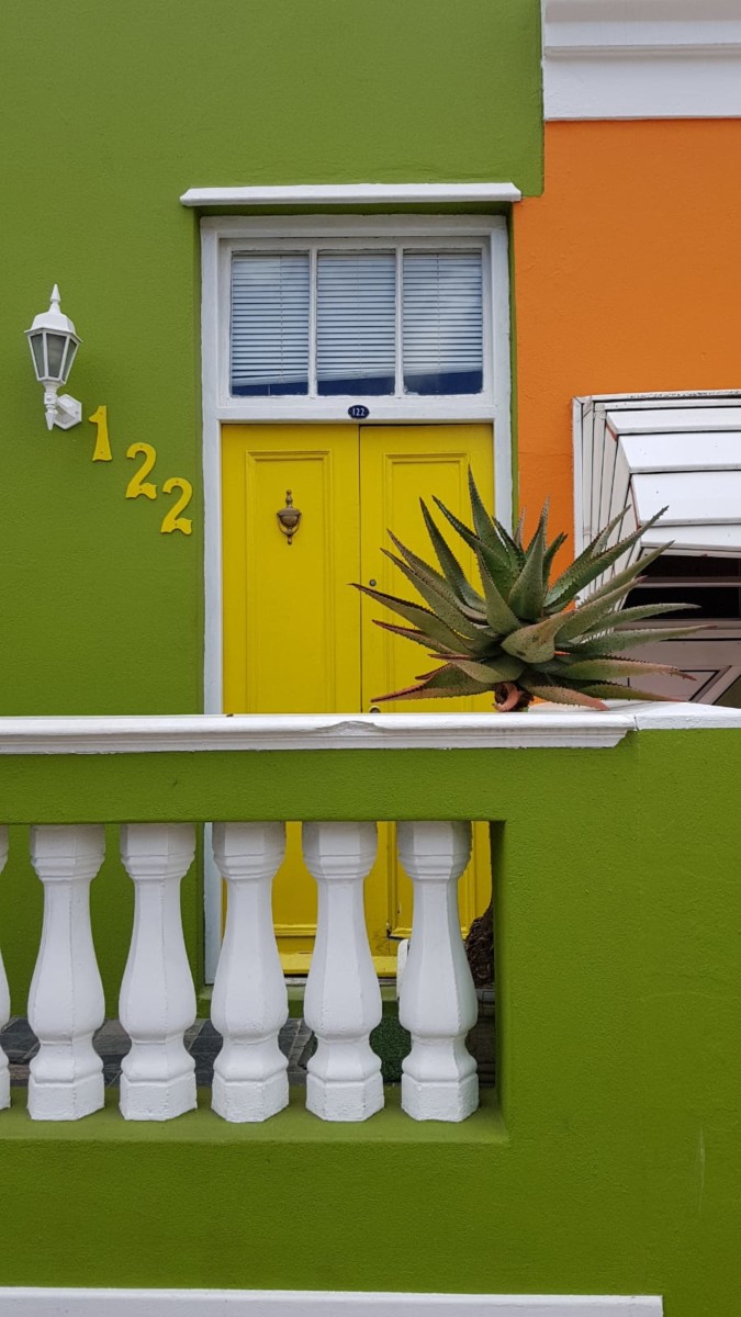 grünes Haus mit gelber eingsngstuer und weissem Gelaender